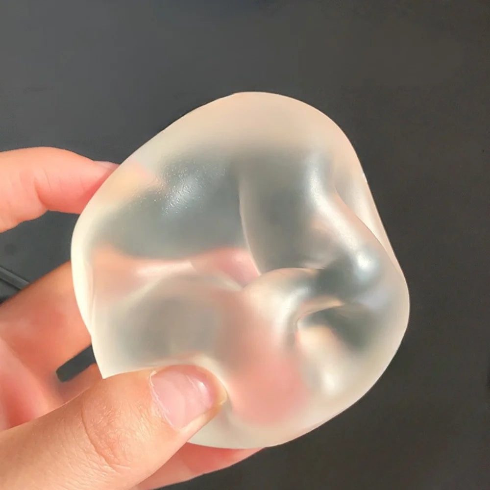 Clear coconut oil squishy ball holding the shape of a hand
