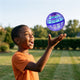 Blue flying orb ball hovering above a boy's open hand in a back yard