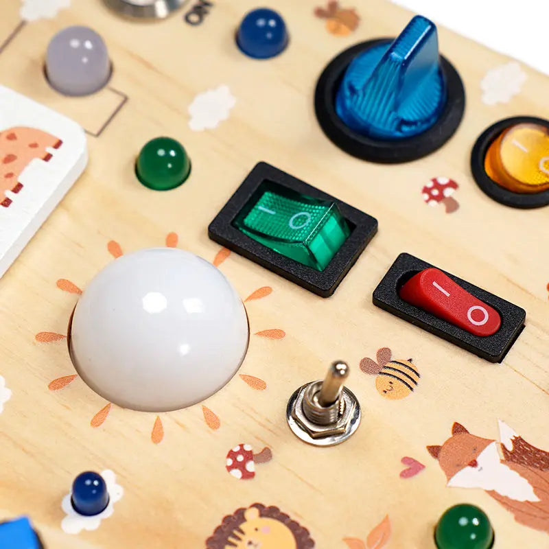 Close-up of the white dome, the green and red rockers and the metal toggle on the wooden board