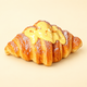 Croissant squishy, golden croissant with custard glaze on a plain golden background