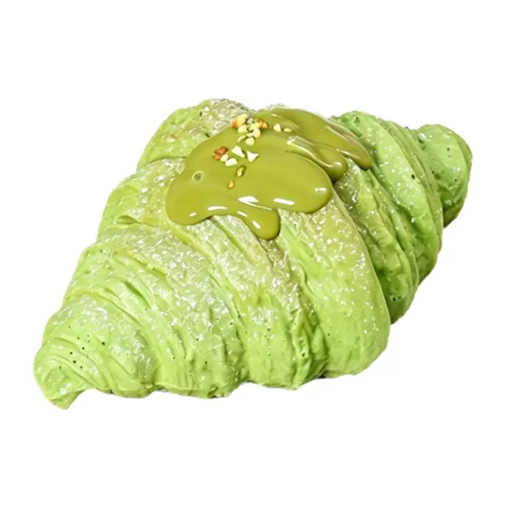 Green croissant squishy toy on a white background