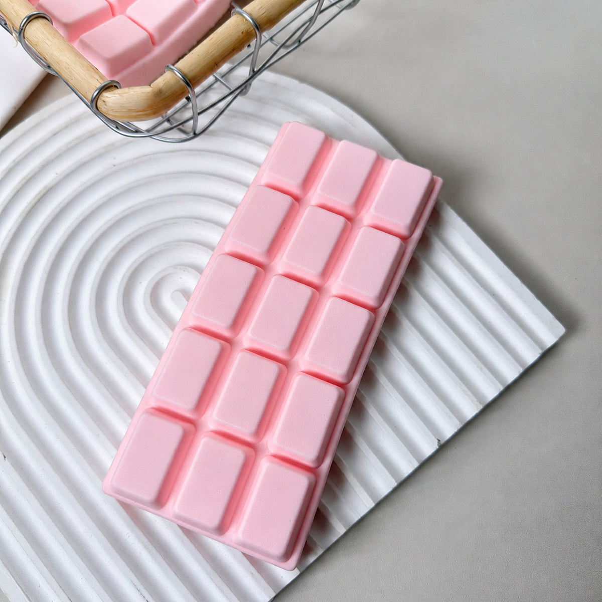 Pink chocolate bar squishy with 15 squares on a white arched tray
