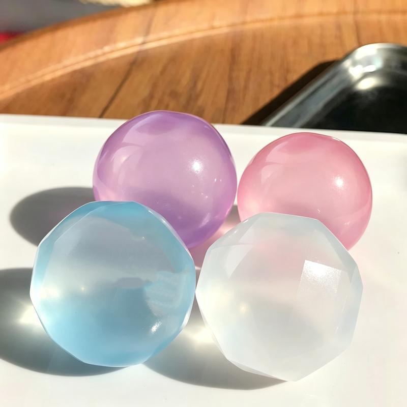 Four coconut oil squishy balls in daylight on a white surface