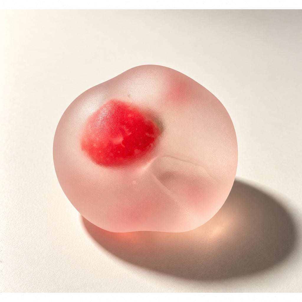 Crystal strawberry squishy: frosted pink ball with a red strawberry inside