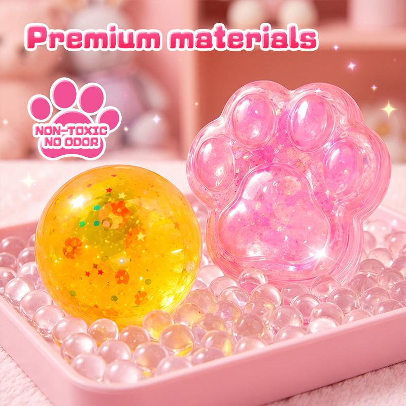 Close-up of a pink cat paw squishy and a yellow glitter ball made with the kit