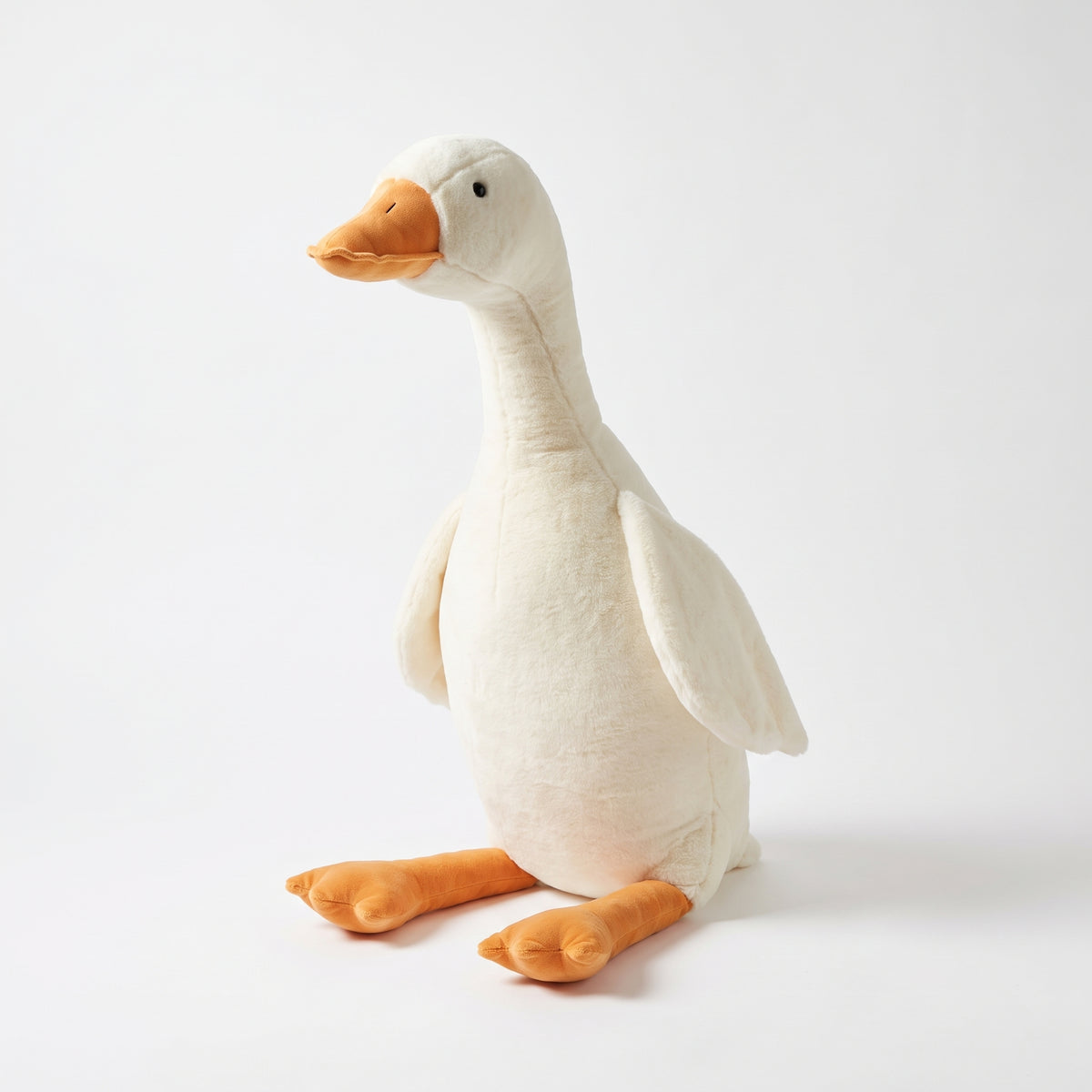 The giant goose plush standing on a white studio background, orange beak and feet