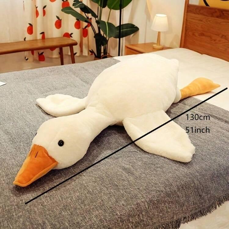 The 51 inch goose plush lying across a bed, used as a body pillow