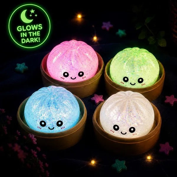 Four glow in the dark dumpling squishies lighting up in a dark room