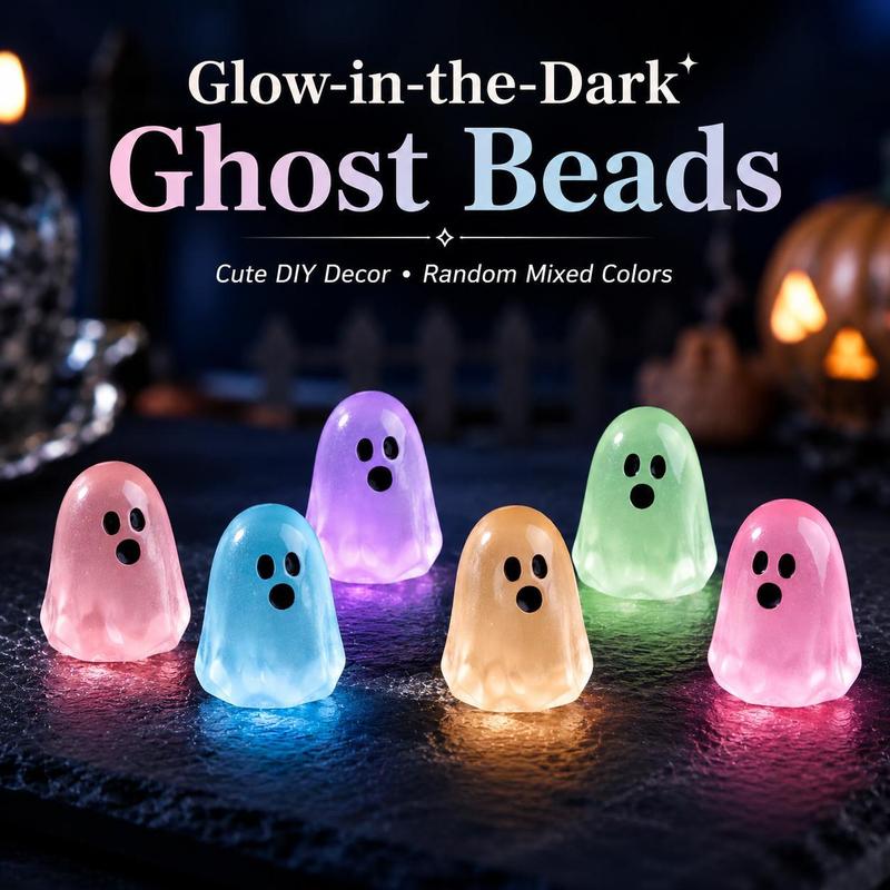 Six pastel glow in the dark ghosts lit up on a dark table at night