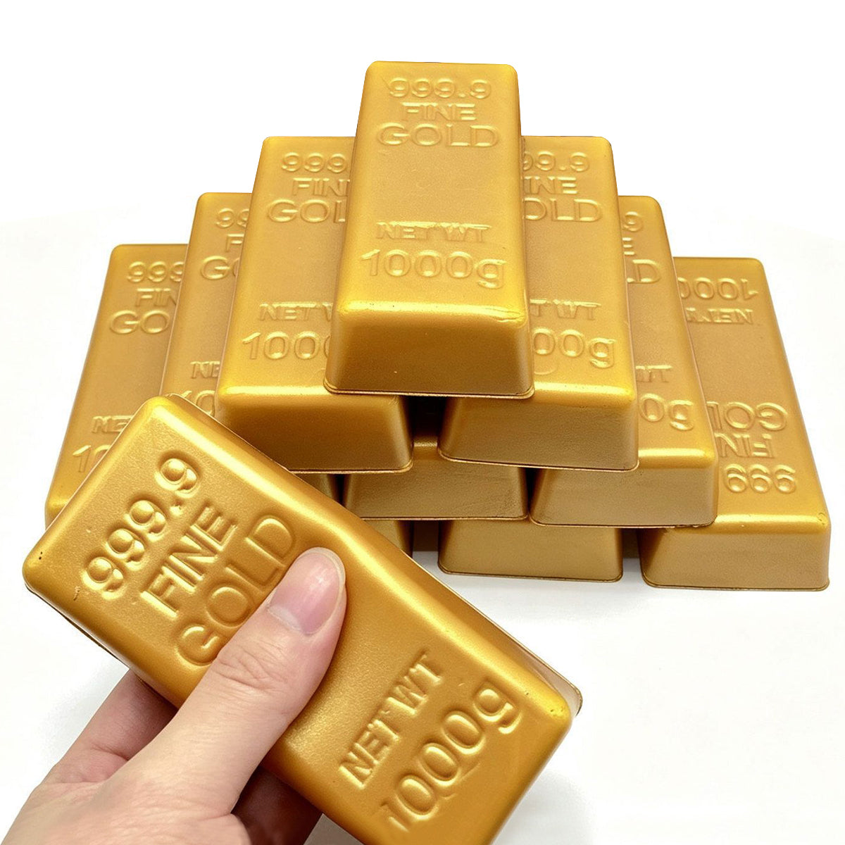 Gold bar squishy held in front of a stacked pile of fake gold bricks