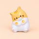 Orange tabby kawaii cat squishy sitting up on a plain peach background