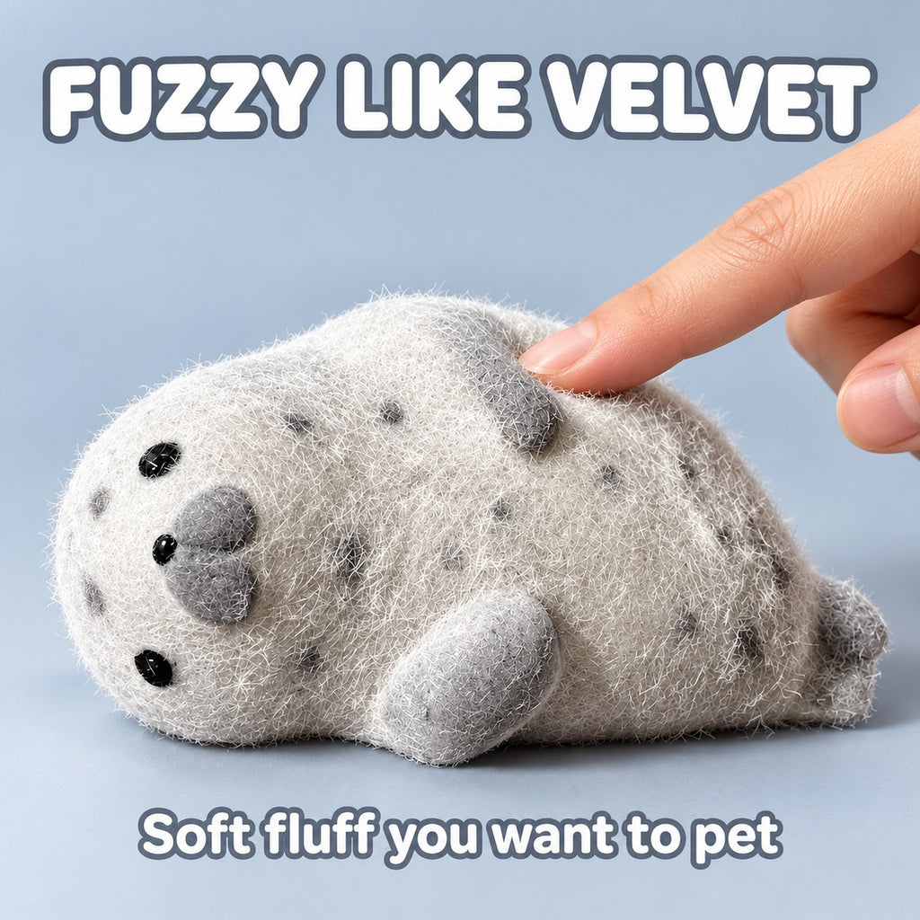 Fingertip stroking the fuzzy coat of the grey seal squishy, text Fuzzy like velvet