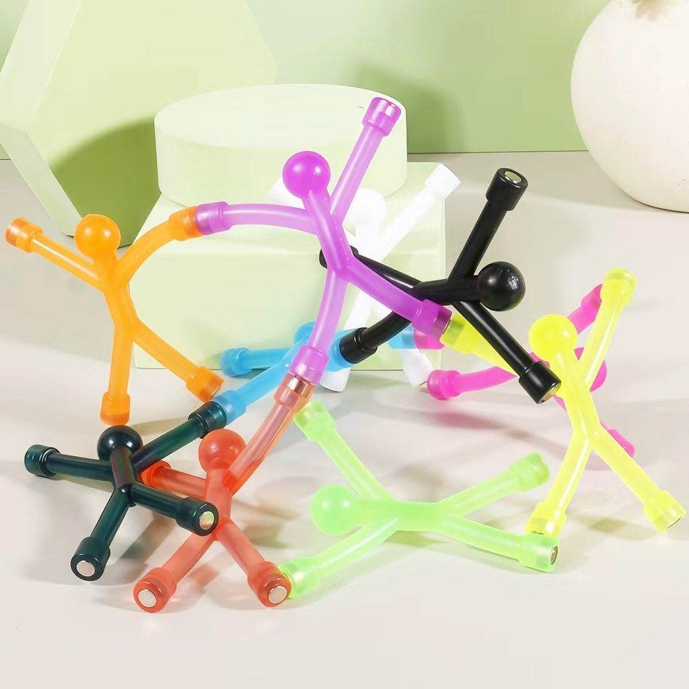 Magnetic stick figures piled up, the small metal magnets visible at hands and feet