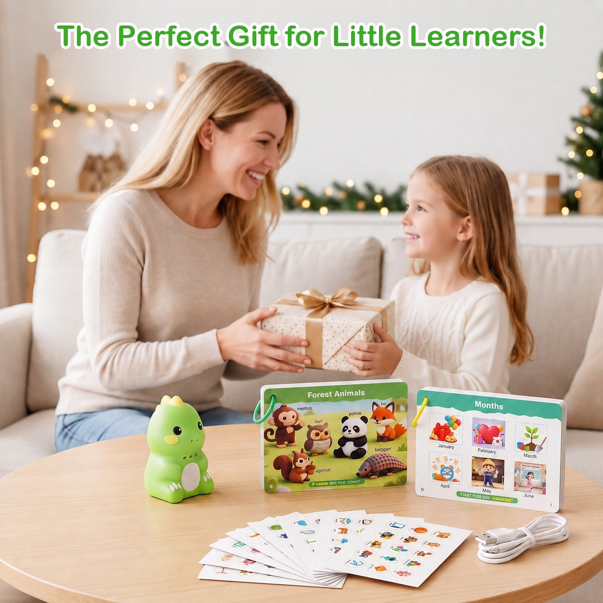 A mother hands a wrapped gift to her daughter; on the table the green dinosaur reader, two picture card sets, sticker sheets and a charging cable