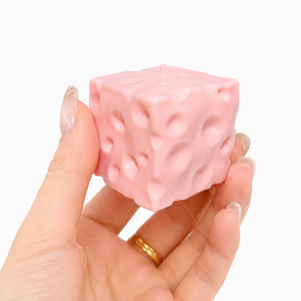 Pink cheese squishy held in a hand