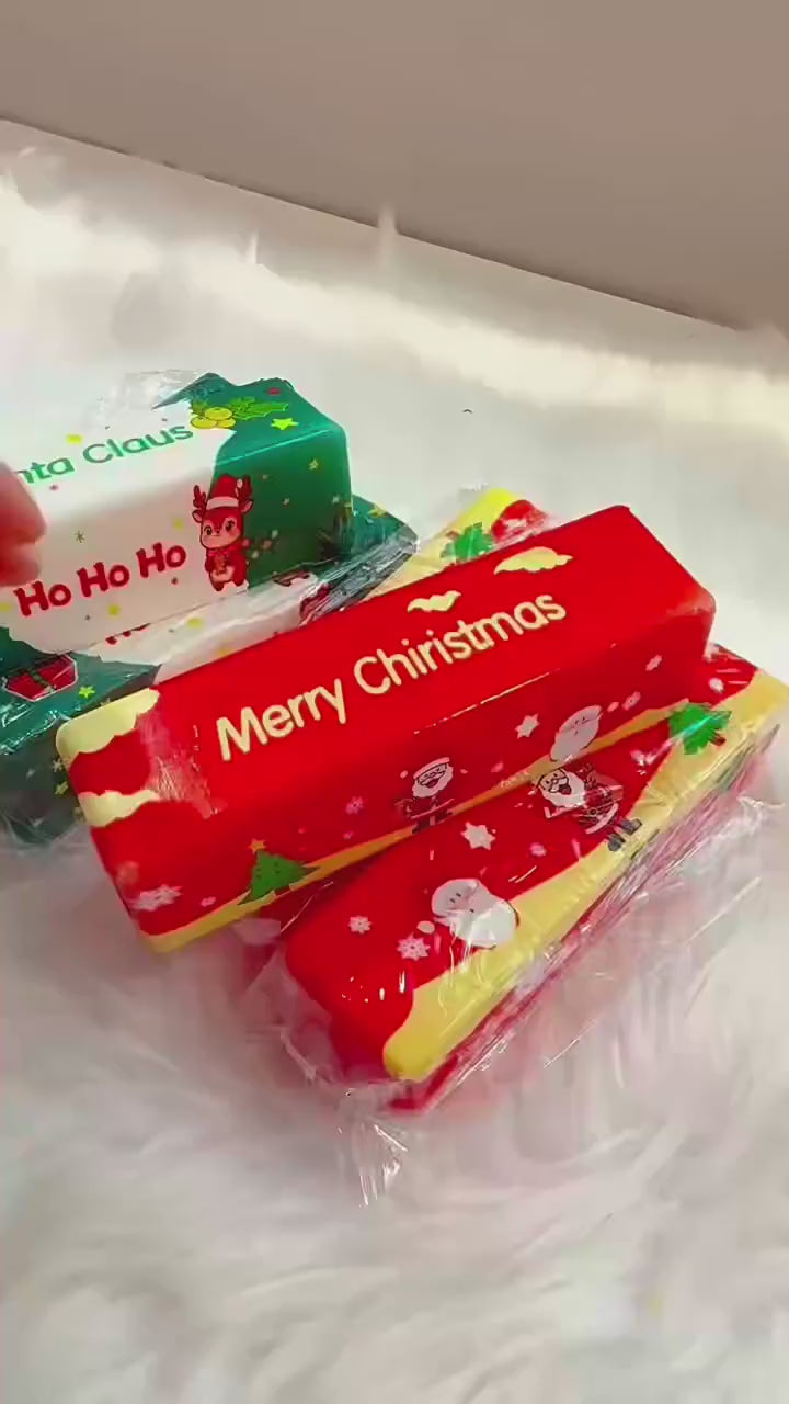 Hands squeezing the red and green Christmas butter squishies, which go back to their stick shape
