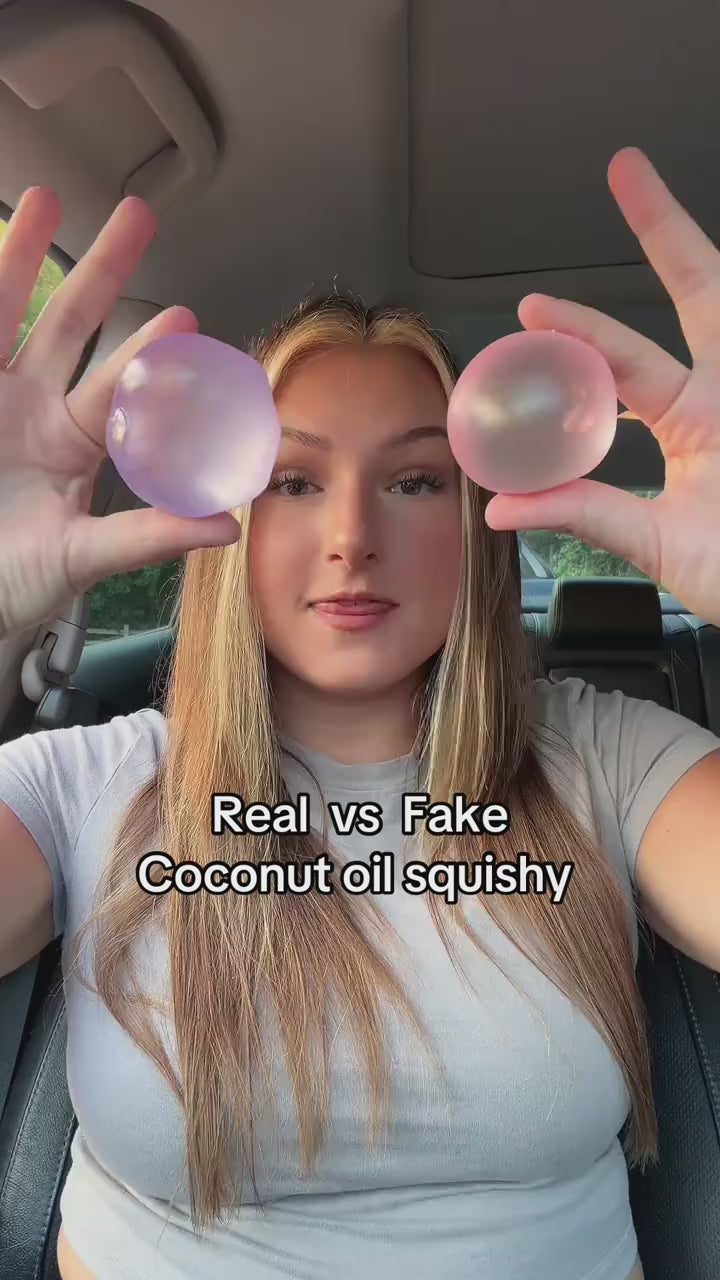 Hands squeezing a coconut oil squishy flat, the dent stays instead of bouncing back