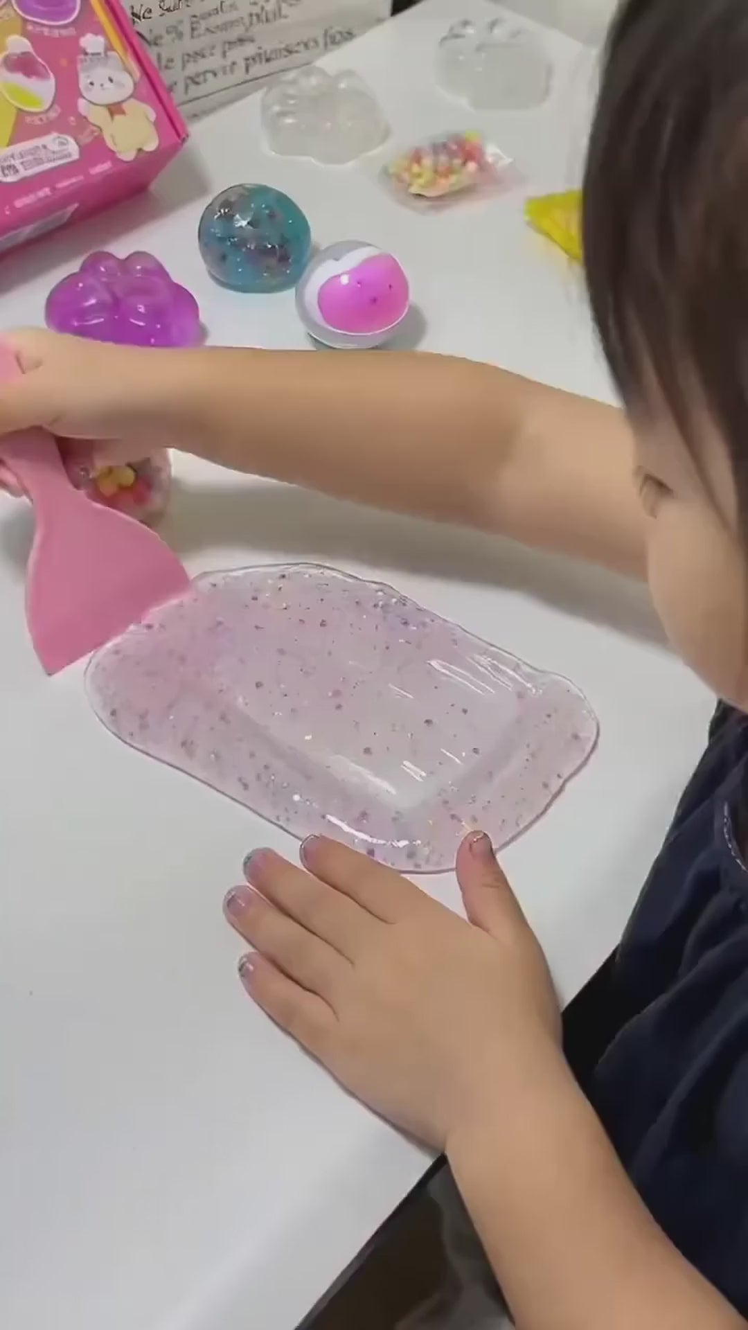 A child making her own squishies with the DIY cat paw kit at the table