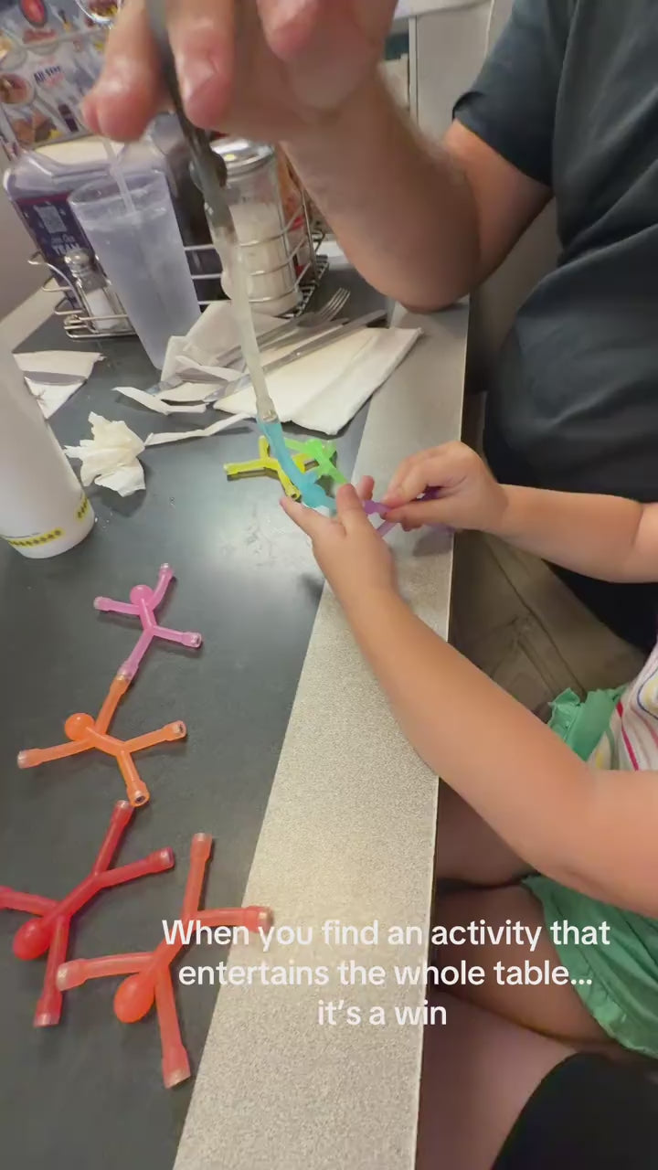A child playing with magnetic stick figures on a restaurant table