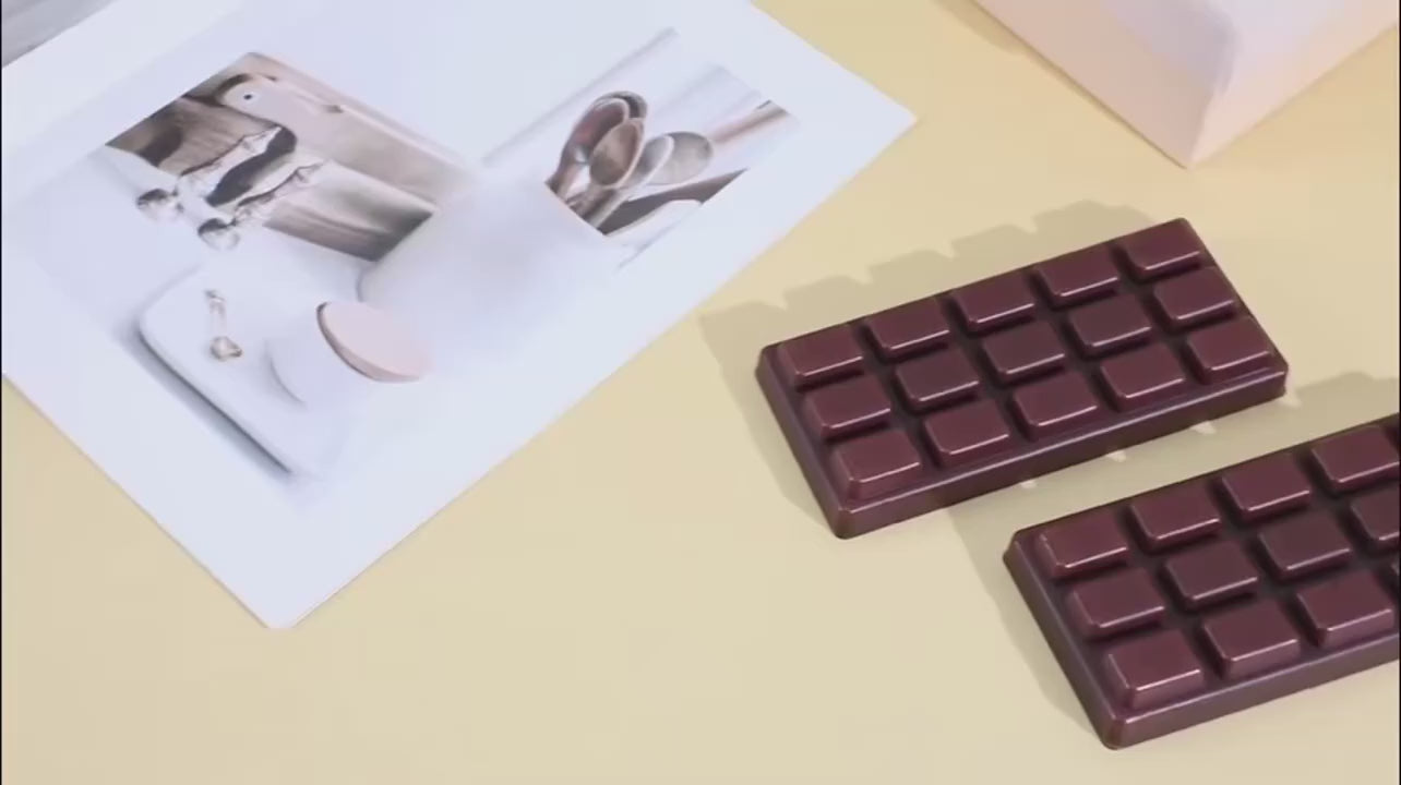 Hands bending and pressing the chocolate bar squishy, which goes back to its shape