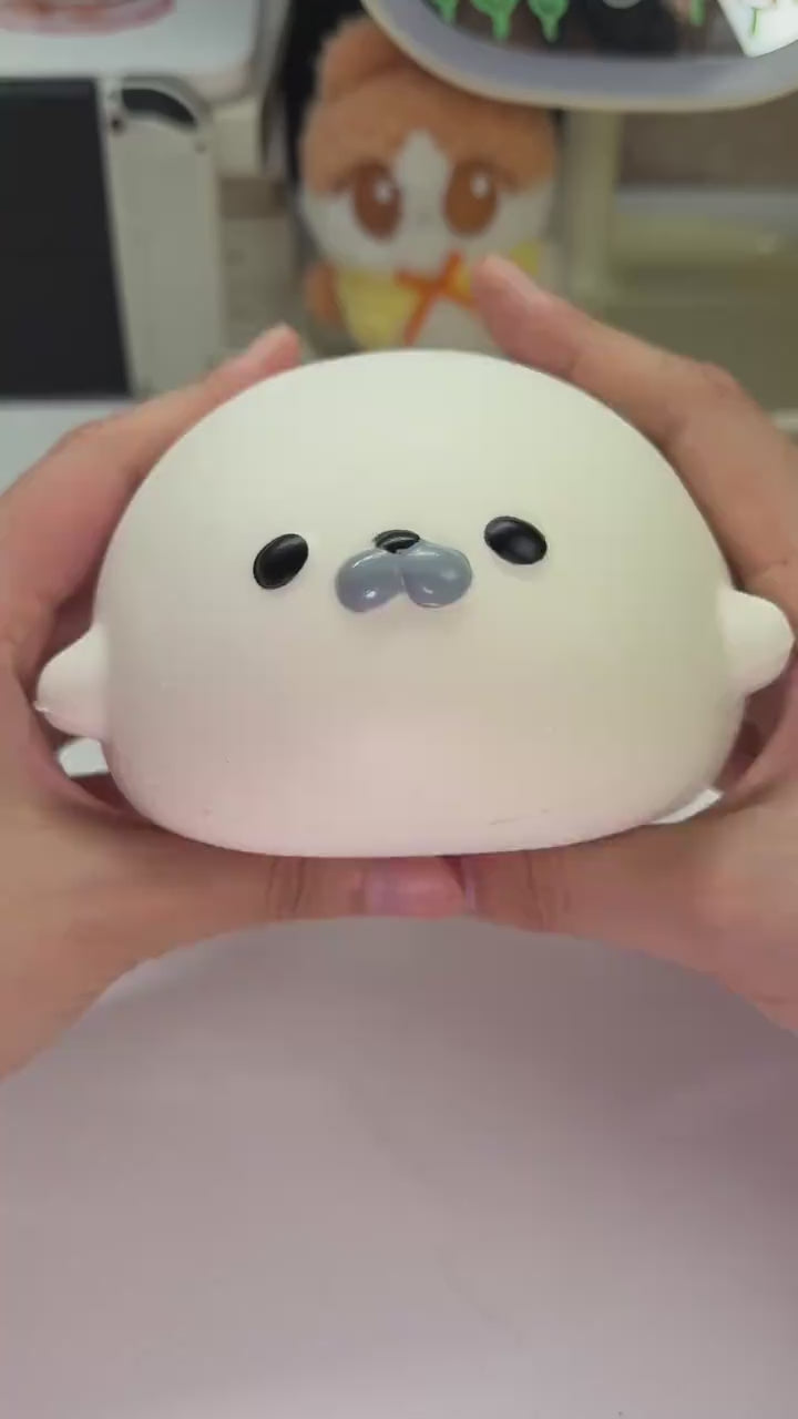 White seal dumpling squishy squeezed slowly in one hand