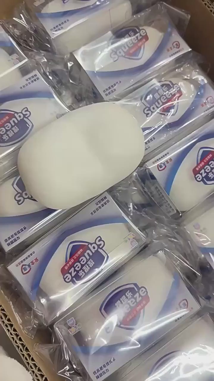 Hand squeezing the white squishy soap bar, the dents stay where you press