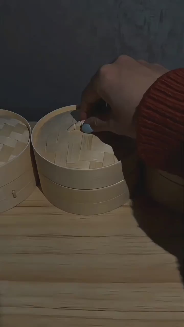 Glow dumpling squishies glowing inside their steamer tins in a dark room
