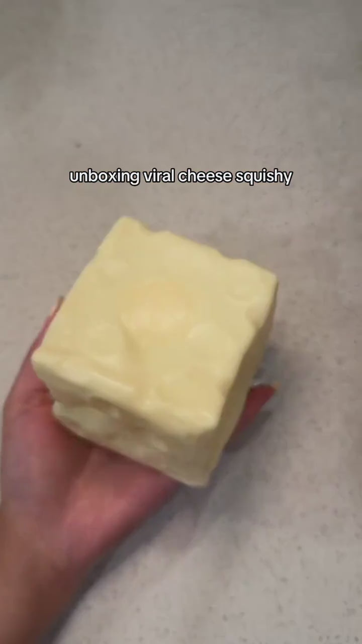 Fingers pressing dents into the moldable cheese squishy, the dents stay, then it is squished flat
