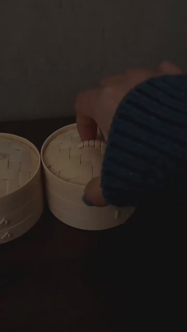 Hands squeezing a glowing dumpling squishy with the lights off