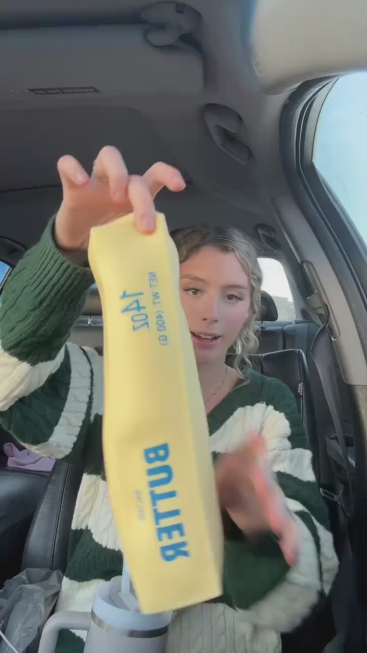 Jumbo butter squishy stretched at arm's length, squeezed, then back in hand
