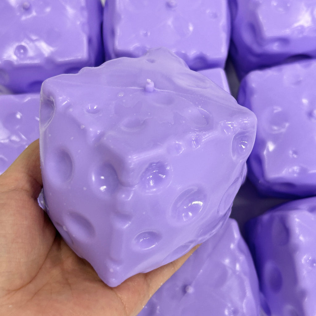 Purple cheese squishy block in a hand