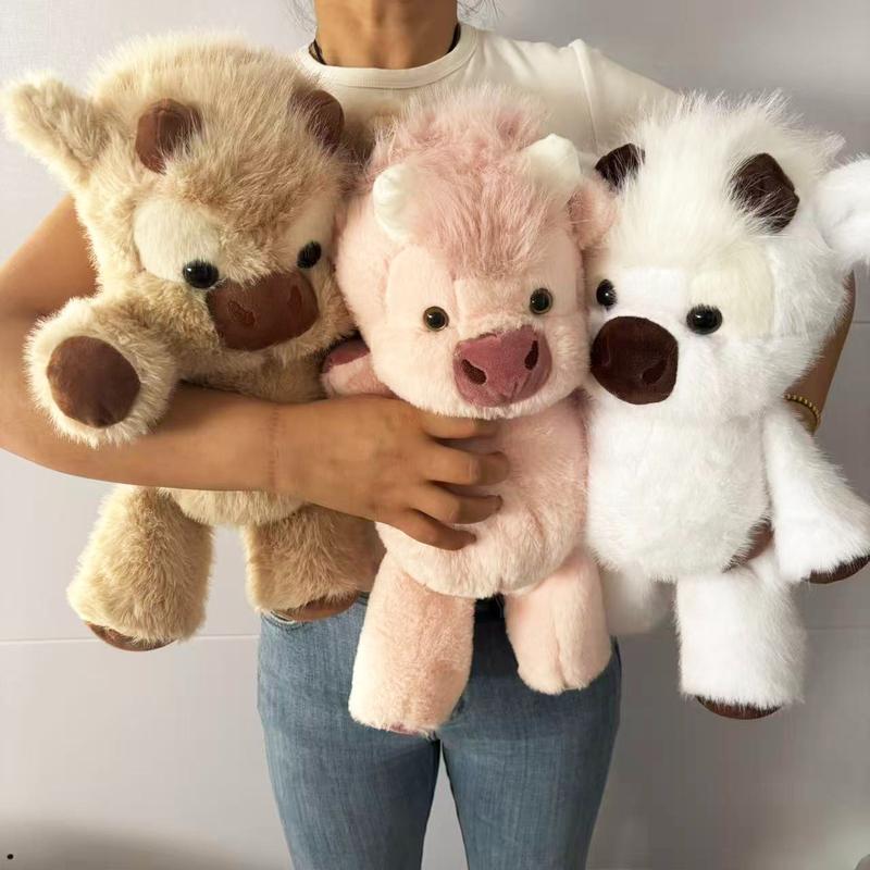 A woman holding three Highland cow plush toys in her arms to show their size