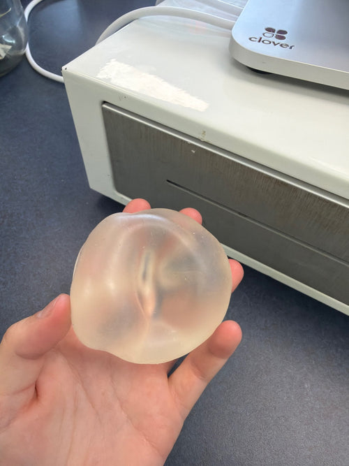 Customer photo of a coconut oil squishy ball held in one hand