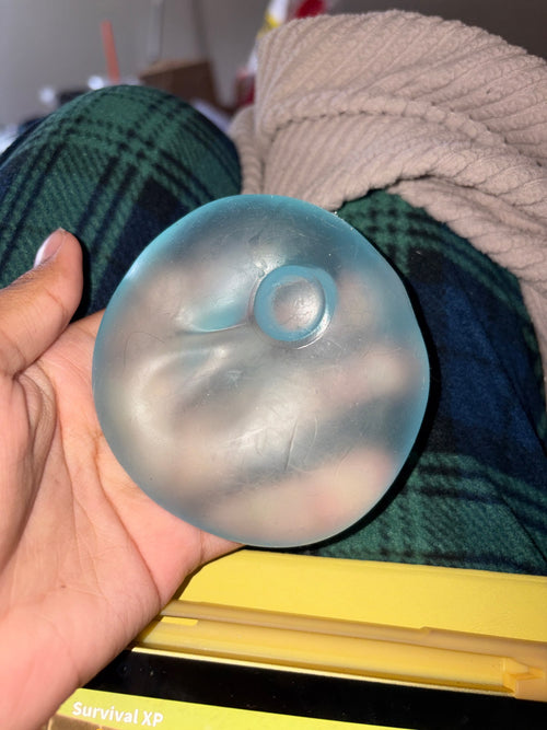 Customer photo of a coconut oil squishy ball held in one hand