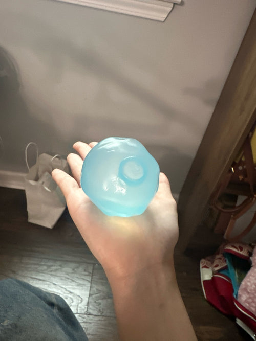 Customer photo of a coconut oil squishy ball held in one hand